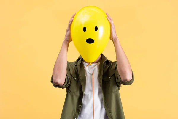 Junger Mann Hält Schockierten Luftballon Vor Gesicht Isoliert Auf Gelb — Stockfoto