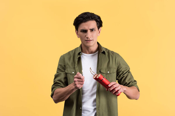 angry man holding dynamite sticks and lighter, isolated on yellow