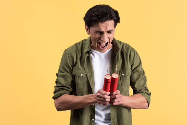 сердитый человек кричит и держит динамит, изолированный на желтый
