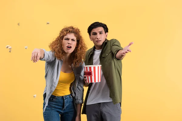 Aggressive Irritated Couple Watching Bad Movie Throwing Popcorn Isolated Yellow — 스톡 사진