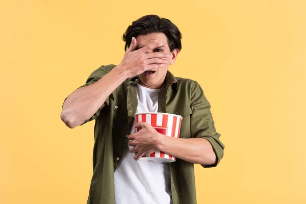 Frightened Young Man Watching Horror Movie Closing Eyes Holding Bucket — Stock Photo, Image