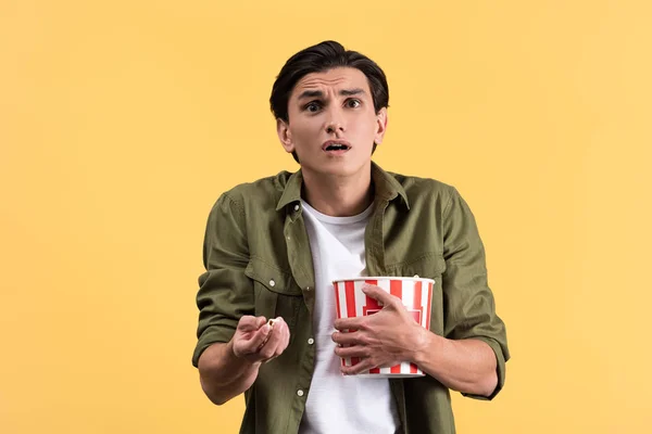 Shocked Young Man Watching Movie Bucket Popcorn Isolated Yellow — 스톡 사진