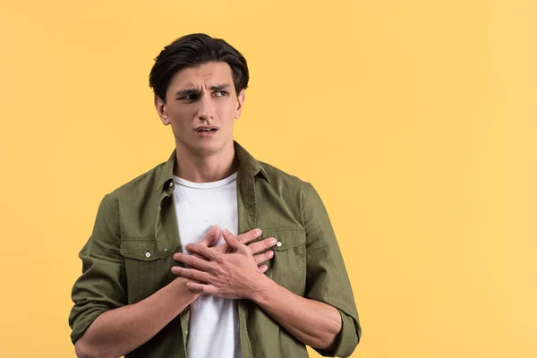 Portrait Worried Young Man Holding Hands Heart Isolated Yellow — Stock Photo, Image