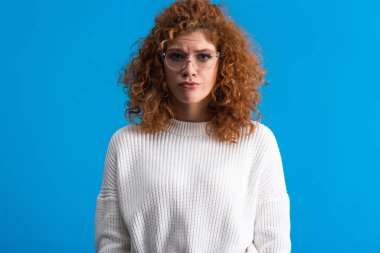 portrait of beautiful upset woman, isolated on blue