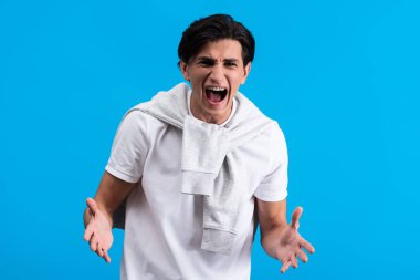 aggressive young man shouting isolated on blue
