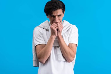portrait of stressed young man, isolated on blue