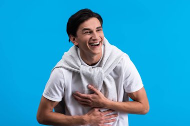 portrait of laughing young man, isolated on blue