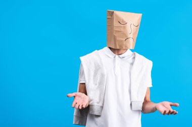 skeptical man with sad paper bag on head, isolated on blue clipart
