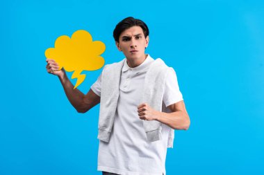 angry man holding fist and yellow cloud speech bubble, isolated on blue