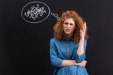 stressed redhead young woman with thought bubble on blackboard
