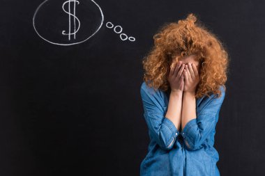 Kara tahtada dolar işaretli hayal kırıklığına uğramış bir kız.