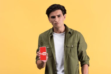 Kyiv, Ukrayna - 18 Kasım 2019: şüpheli bir adam ekranda youtube uygulaması ile akıllı telefon gösteriyor.