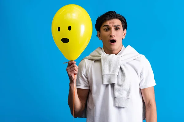 Shocked Young Man Holding Yellow Emotional Balloon Isolated Blue — Stock Photo, Image