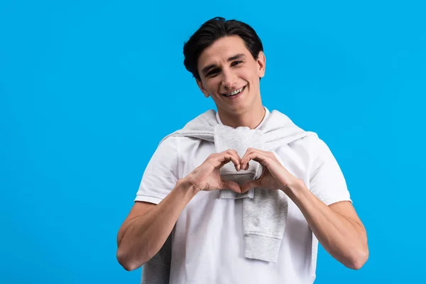 Lächelnder Junger Mann Macht Herzzeichen Mit Händen Isoliert Auf Blauem — Stockfoto