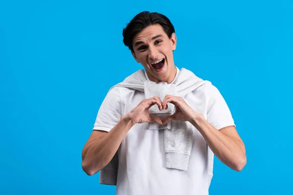 Portrait Excited Young Man Making Heart Sign Hands Isolated Blue — Stock fotografie