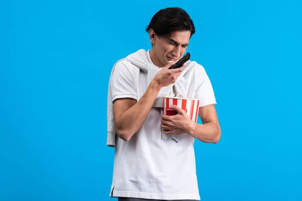 Crying Young Man Watching Remote Controller Popcorn Isolated Blue — Stock Photo, Image