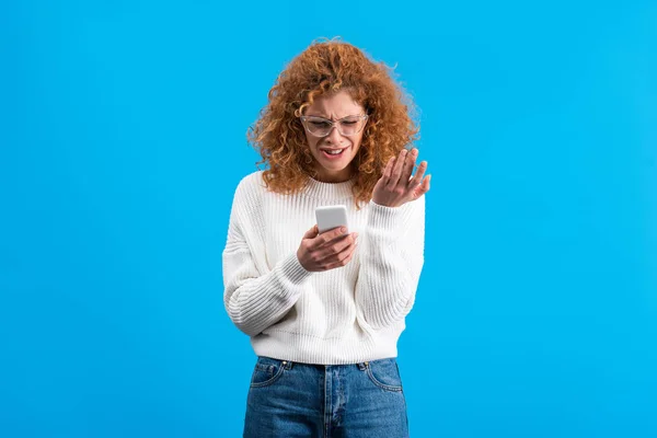 Redhead Angry Woman Eyeglasses Using Smartphone Isolated Blue — Stock Photo, Image