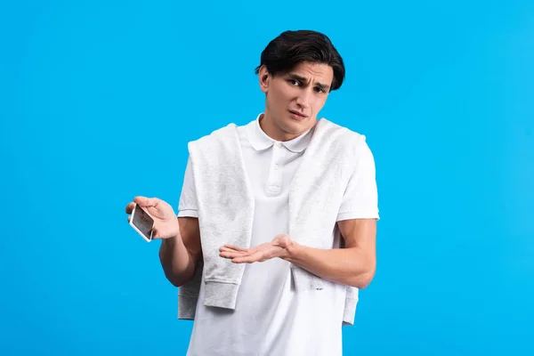 Skeptical Young Man Shrug Gesture Using Smartphone Isolated Blue — Stock Photo, Image