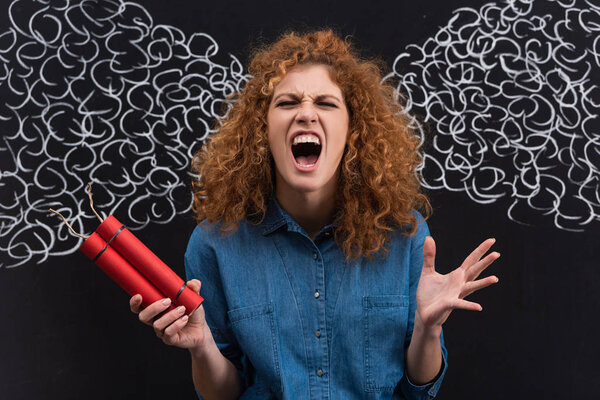 angry redhead woman shouting and holding dynamite, with steam drawing on blackboard