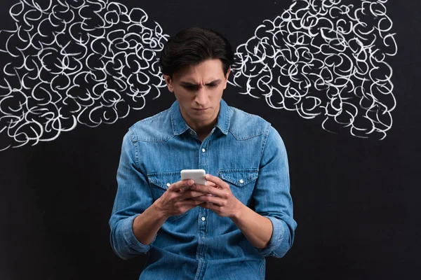 Concentrated Young Man Using Smartphone Steam Ears Drawing Chalkboard — Stock Photo, Image