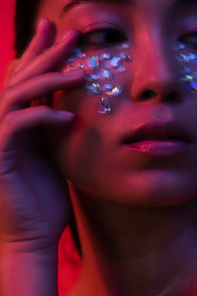 close up view of beautiful asian girl with rhinestones on face, motion blur