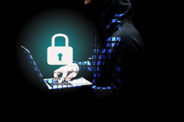 cropped view of hacker in hood using laptop near padlock on black  clipart