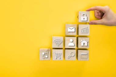 top view of man holding wooden cube with padlock isolated on yellow  clipart