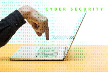 Siber güvenlik harflerinin yanındaki dizüstü bilgisayarı işaret eden bir adam beyaz harflerle işaretlenmiş. 