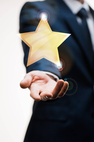 cropped view of businessman in suit with outstretched hand near star on white, quality concept 