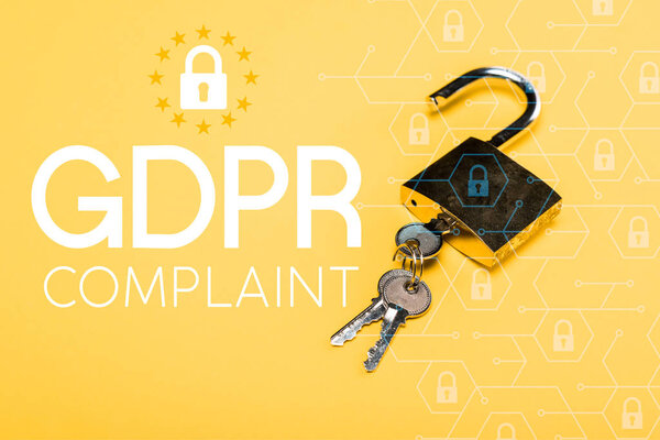 padlock with keys near gdpr complaint lettering on yellow 