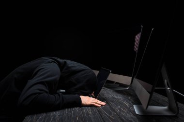 üzgün bilgisayar korsanı bilgisayar monitörlerinin yanında yatıyor boş ekran siyah üzerine izole 