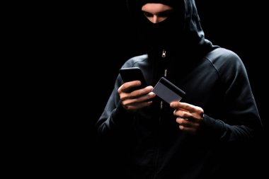Akıllı telefon kullanan ve siyah kart kullanan bir bilgisayar korsanı. 