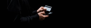 Akıllı telefon kullanan ve kredi kartını izole edilmiş halde tutan hackerın panoramik görüntüsü 