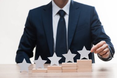 cropped view of businessman in formal wear touching star isolated on white, quality concept  clipart