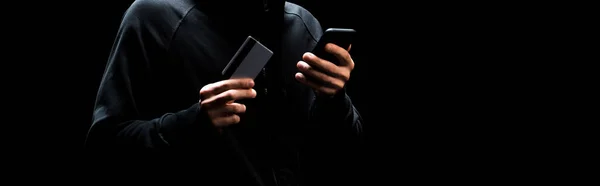 Tiro Panorâmico Jovens Hackers Usando Smartphone Segurando Cartão Crédito Isolado — Fotografia de Stock