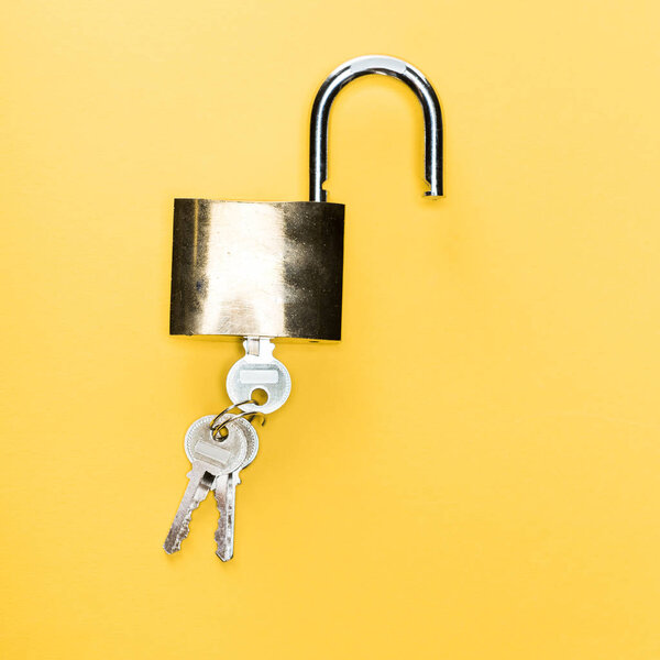 top view of padlock with keys isolated on yellow