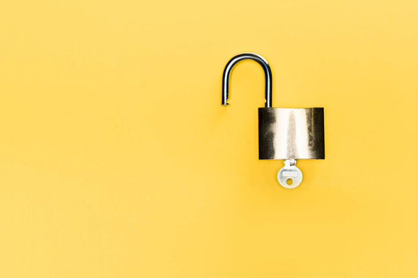 top view of metallic locker and key isolated on yellow
