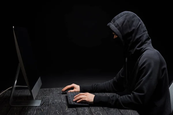 Hacker Mit Kapuze Schaut Auf Computermonitor Mit Leerem Bildschirm Auf — Stockfoto