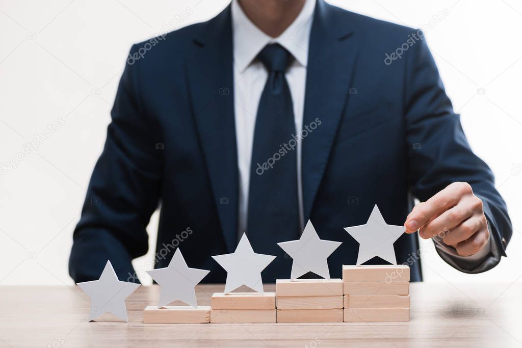 cropped view of businessman in formal wear touching star isolated on white, quality concept 