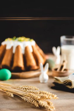 Lezzetli paskalya pastasının yanındaki masada buğday kulaklarının seçici odağı 