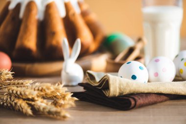 selective focus of linen napkins with dotted eggs near easter bread and figurine of rabbit 