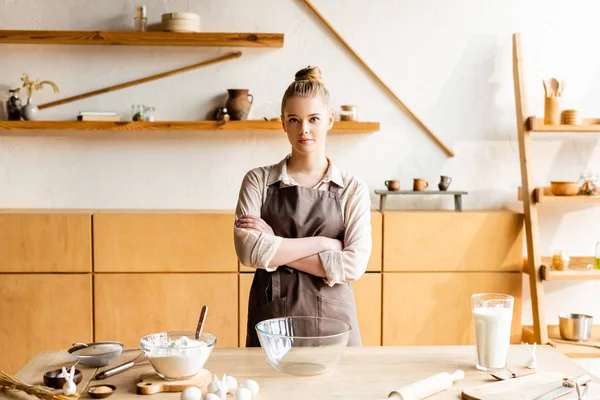 Jonge Vrouw Met Gekruiste Armen Buurt Van Ingrediënten Paashaas Beeldjes — Stockfoto