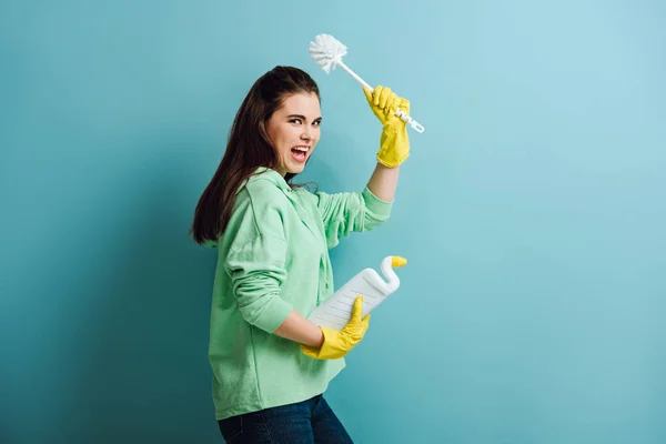 Irritierte Hausfrau Hält Kolben Erhobener Hand Und Schreit Auf Blauem — Stockfoto