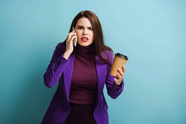 Menina Zangada Falando Smartphone Segurando Café Para Fundo Azul — Fotografia de Stock