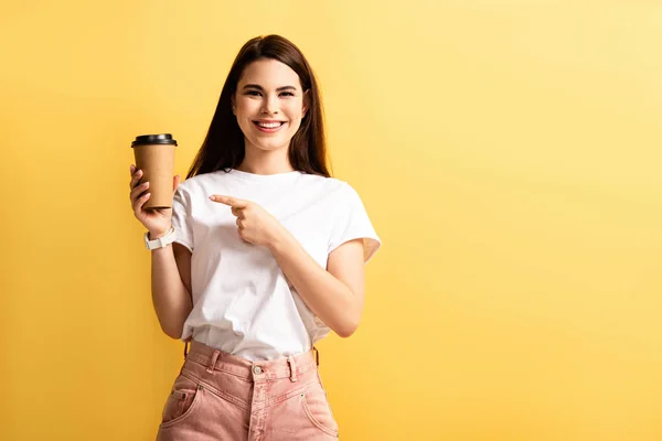 Cheerful Girl Pointing Finger Coffee While Smiling Camera Isolated Yellow — Stock Photo, Image
