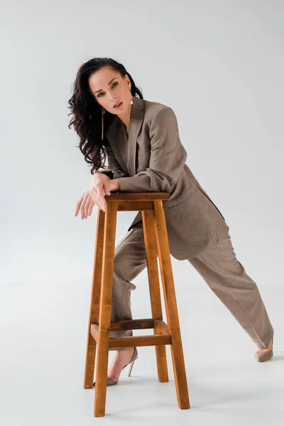 Stylish Woman Suit Stool Looking Camera Grey Background — Stock Photo, Image