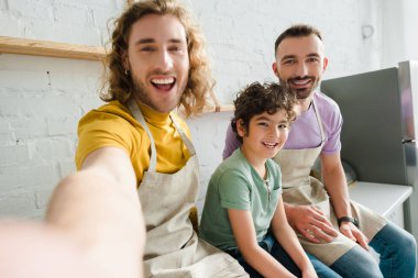 Yakışıklı homoseksüel erkeklerin seçici odağı tatlı melez çocukla gülümsüyor. 