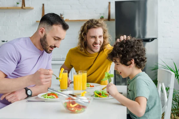 幸せな同性愛者の男性がかわいい混合人種の息子とサラダを持っている — ストック写真