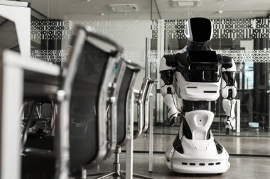 Modern ofisin konferans salonunda duran insansı robotun seçici odağı