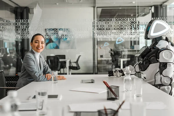 Selective Focus Smiling Asian Businesswoman Looking Camera While Sitting Desk — Stock Photo, Image